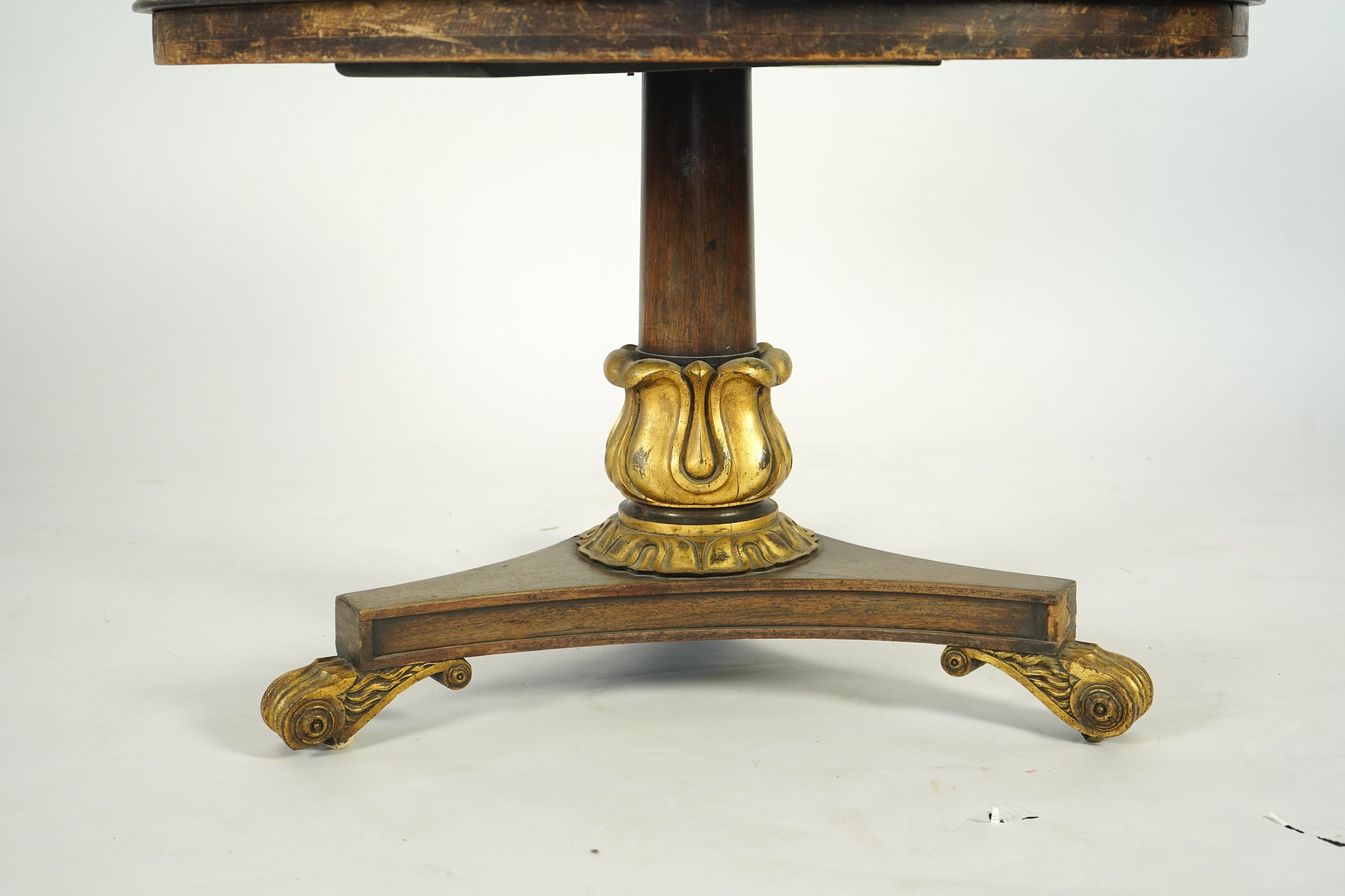 A George IV parcel gilt mahogany circular slate top centre table